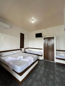 1 dormitorio con 2 camas y TV de pantalla plana en Pargos Club de Salinas, en Salinópolis