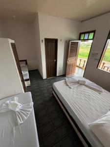 2 camas individuales en una habitación con ventana en Pargos Club de Salinas en Salinópolis