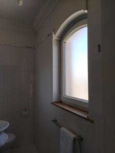 La salle de bains est pourvue d'une fenêtre, de toilettes et d'un lavabo. dans l'établissement Julian’s Place, à San Ġiljan