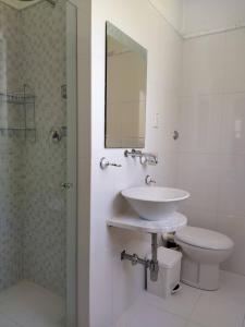 La salle de bains est pourvue d'un lavabo, de toilettes et d'un miroir. dans l'établissement Julian’s Place, à San Ġiljan