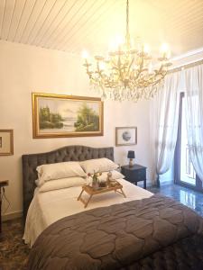 - une chambre avec un grand lit et un lustre dans l'établissement la corte dei filangieri rooms, 