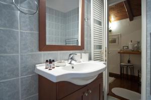 特尔斐Cozy Attic Suite - Elia Apartments Chrisso的带白色水槽和镜子的浴室