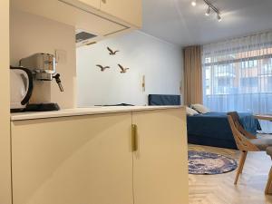 a kitchen and a living room with a couch at Apartament Morski Spokój Solny Resort in Kołobrzeg