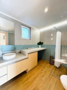 La salle de bains est pourvue d'un lavabo et d'un grand miroir. dans l'établissement Cosy apartment with Great Views, à Longá