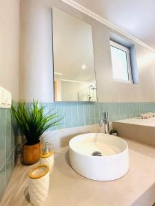 La salle de bains est pourvue d'un lavabo et d'un grand miroir. dans l'établissement Cosy apartment with Great Views, à Longá