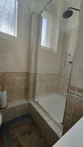 y baño con ducha y puerta de cristal. en Bel appartement, Bry- sur- Marne, en Bry-sur-Marne