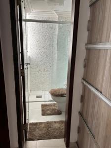 a bathroom with a toilet and a glass door at Apto e escritório no Renascença in São Luís +2 photos