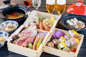 stół z dwoma tacami jedzenia i kieliszkami piwa w obiekcie NAGOMI CAMP - Vacation STAY 48648v w mieście Nasushiobara