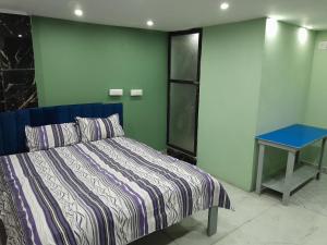 a bedroom with a bed and a blue table at M k home stay in Ujjain