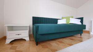 Sofá verde con 2 almohadas y mesa auxiliar en Pokoje u Agnieszki, en Łuków