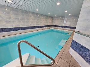 a large swimming pool with a tile wall at ELAfora Studio in Salouf