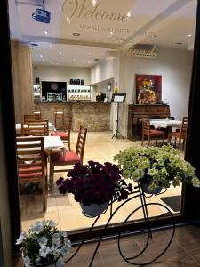 a restaurant with tables and chairs and flowers on a table at Moudania Mare Hotel in Nea Moudania