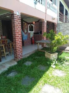 a patio with a table and a brick building at Espaço familiar in Maricá