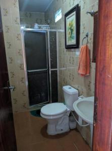 a bathroom with a toilet and a shower and a sink at Espaço familiar in Maricá