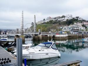 a white boat docked at a dock in a harbor at Luxe Torquay Central Apartments Overlooking Harbour Near Babbacoombe Beach in Torquay