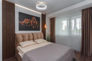 a bedroom with a large bed and a chandelier at Apartament Paris in Durleşti