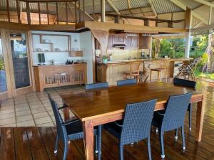 una cucina con tavolo e sedie in legno di VILLA O VAI a Teahupoo