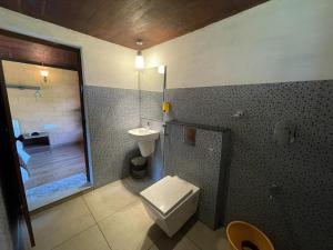 uma casa de banho com um WC, um lavatório e um chuveiro em Bhuvi Wayanad Natural Tea Plantation Resort em Wayanad