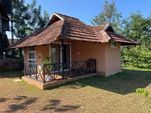 a small house with a porch and a roof at Bhuvi Wayanad Natural Tea Plantation Resort in Wayanad
