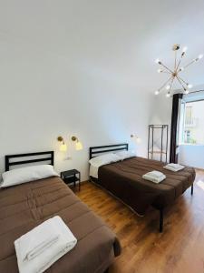 a bedroom with two beds and a large window at Prime Rooms Oriani in Florence