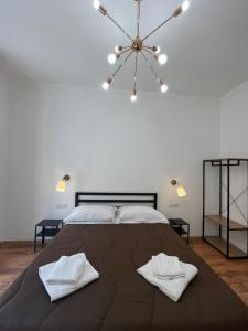 a bedroom with a large bed with two white towels on it at Prime Rooms Oriani in Florence