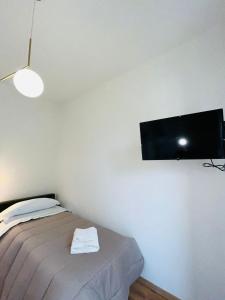 a bedroom with a bed and a flat screen tv on the wall at Prime Rooms Oriani in Florence