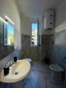 a white bathroom with a sink and a toilet at Prime Rooms Oriani in Florence