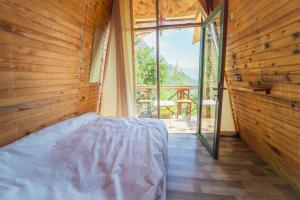 a bedroom with a bed and a large window at Shiva Camp in Faralya