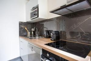 a kitchen with a sink and a stove top oven at 4 pièces 8 personnes proche aéroport,tramway in Nice