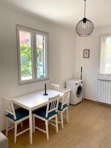 a dining room with a white table and chairs at Il giardino al mare in Varazze +16 photos