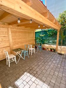 a patio with a table and chairs under a roof at Il giardino al mare in Varazze