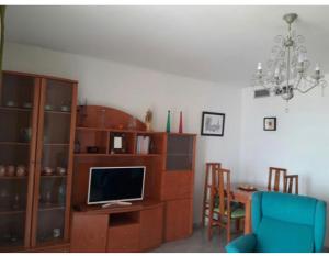 ein Wohnzimmer mit einem TV und einem Schreibtisch mit einem Computer in der Unterkunft Apartamento El Mirador in Aguadulce