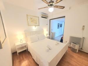 a bedroom with a white bed and a ceiling fan at Kavouri Seaside 85sqm Apartment 5' from the beach in Athens +31 photos