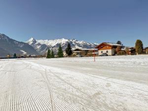 a snow covered road with mountains in the background at Chalet Panoramablick Zell am See in Zell am See