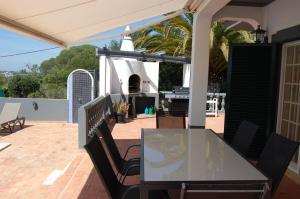 eine Terrasse mit einem Tisch und Stühlen auf einer Terrasse in der Unterkunft Villa Monte Alegrete with sea view in Santa Bárbara de Nexe