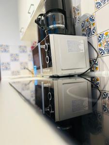 eine Mikrowelle auf einem Glastisch in der Unterkunft Blühendes Balkonwohnung mit Traumaussicht in Saarbrücken