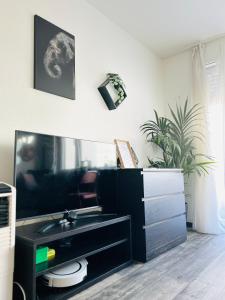 ein Wohnzimmer mit einem Fernseher und einem schwarzen Schrank in der Unterkunft Blühendes Balkonwohnung mit Traumaussicht in Saarbrücken