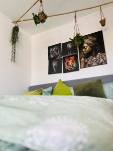 Schlafzimmer mit einem Bett und Bildern an der Wand in der Unterkunft Blühendes Balkonwohnung mit Traumaussicht in Saarbrücken