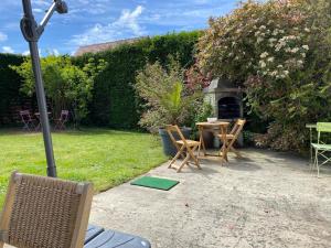 d'une terrasse avec une table et des chaises dans la cour. dans l'établissement Domaine de la coqueraine, à Ouistreham