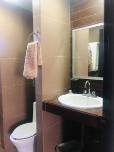 uma casa de banho com um lavatório, um WC e um espelho. em Hotel nuevo atardecer em Cabo San Lucas