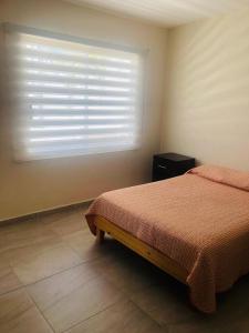 um quarto com uma cama e uma janela com persianas em Hotel nuevo atardecer em Cabo San Lucas