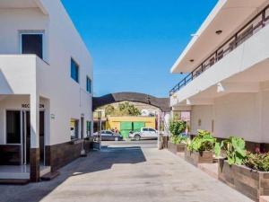 um beco vazio entre dois edifícios com carros num parque de estacionamento em Hotel nuevo atardecer em Cabo San Lucas