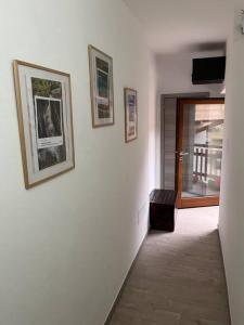 un corridoio con tre foto su un muro bianco di Casa Mario a Riva del Garda