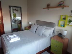 una camera da letto con un grande letto bianco e uno specchio di Val do Fragoso a Vigo