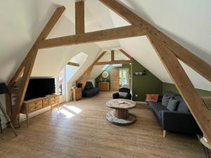 an attic living room with wooden beams and a table at La Parenthèse in Régnauville