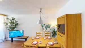 ein Esszimmer mit einem Holztisch und einem TV in der Unterkunft Alpine Style Kaprun in Kaprun