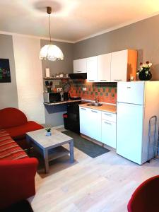 uma cozinha com armários brancos e uma mesa num quarto em Apartma Xanadu em Slovenske Konjice