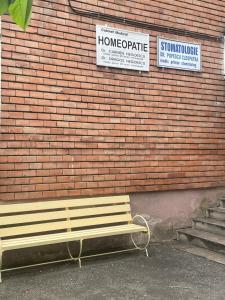 a wooden bench sitting in front of a brick wall at STUDIO 22 in Craiova