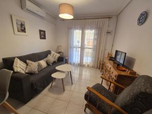 ein Wohnzimmer mit einem Sofa und einem Tisch in der Unterkunft Gladmar Apartment in La Mata
