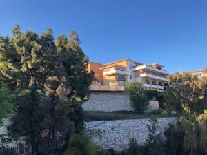une grande maison au-dessus d'un mur en pierre dans l'établissement Bed & Breakfast Villa Botánica, à Malaga